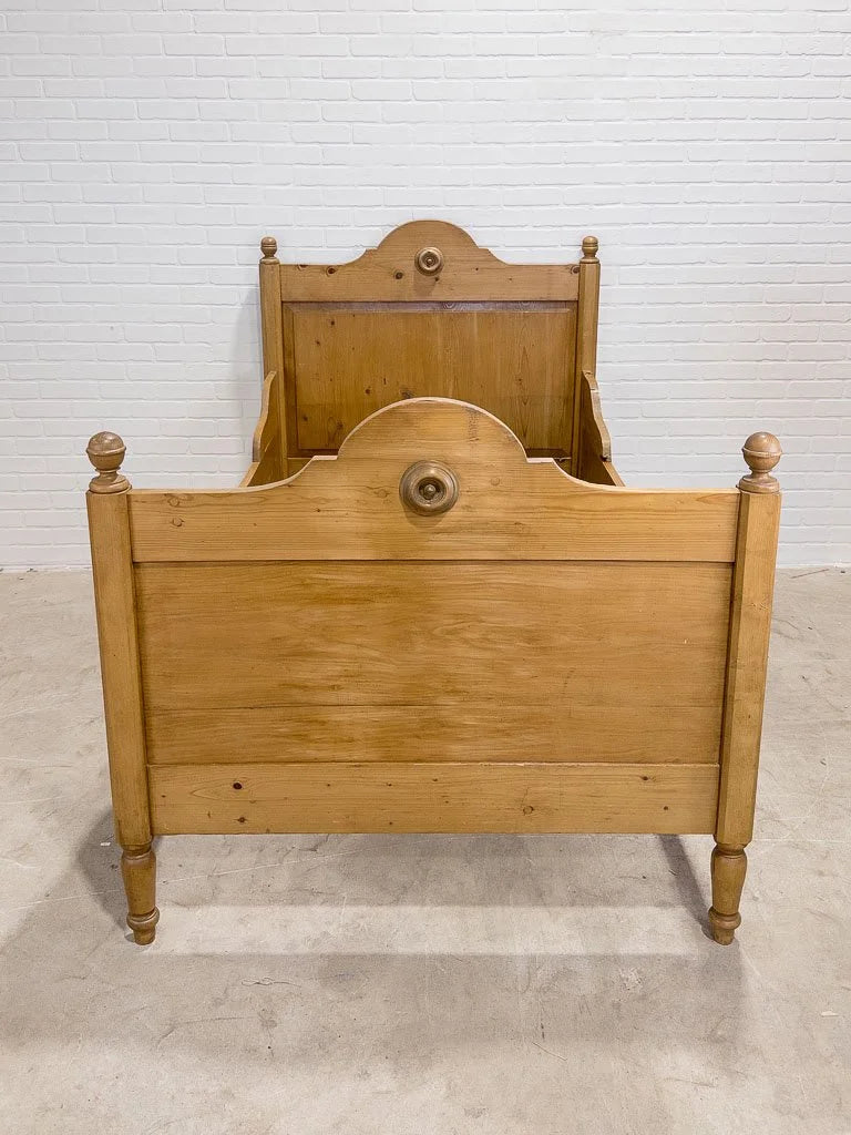 Antique English pine sleigh bed with turned rosette