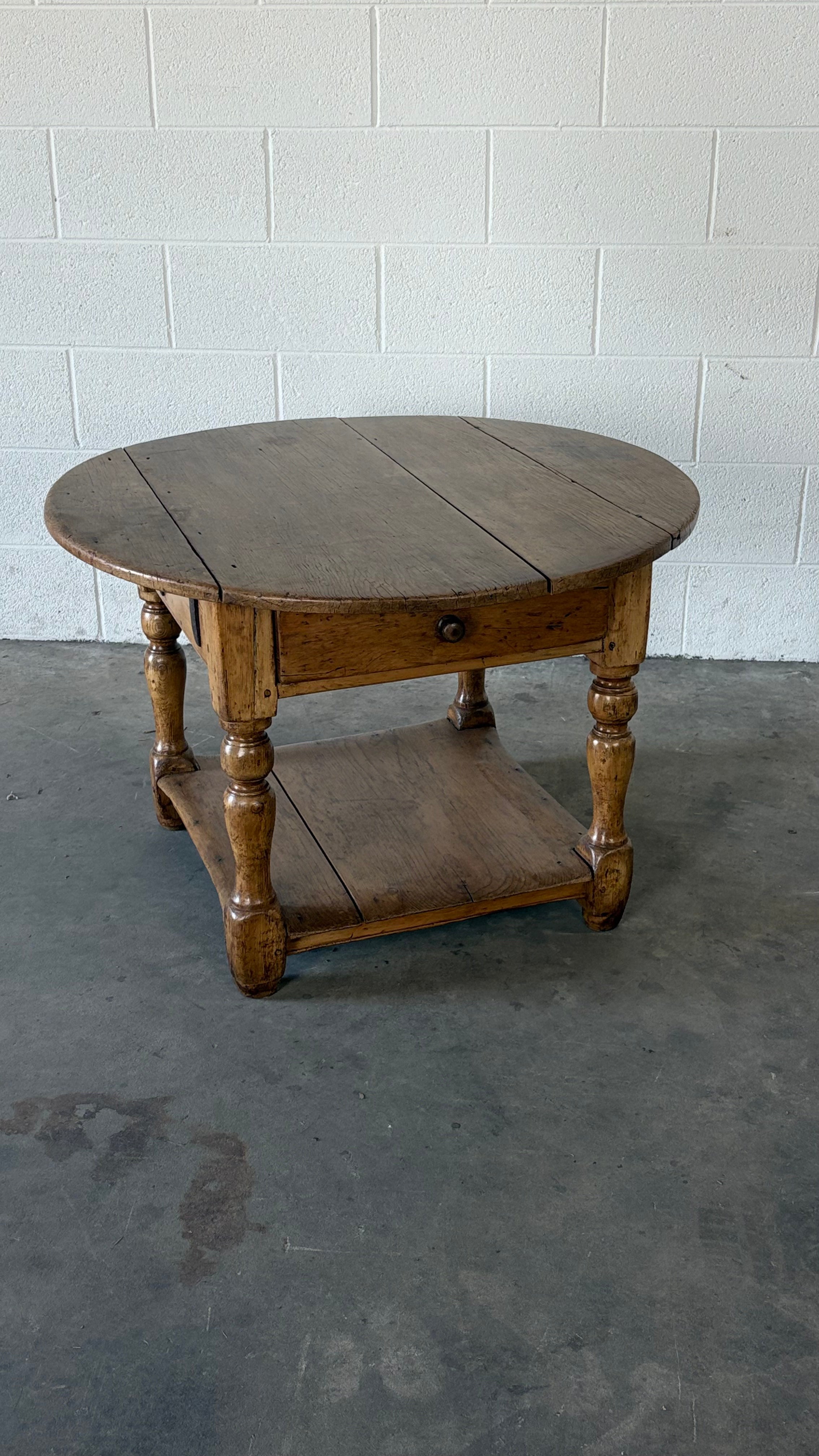 Small round pine coffee table with lower shelf