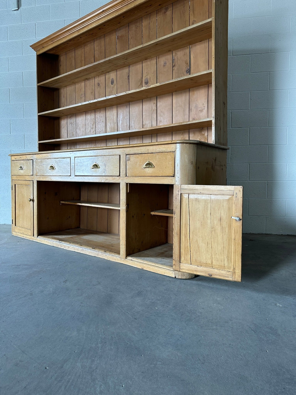 Monumental English pine kitchen dresser with brass pulls and a rounded base - House on Horizon