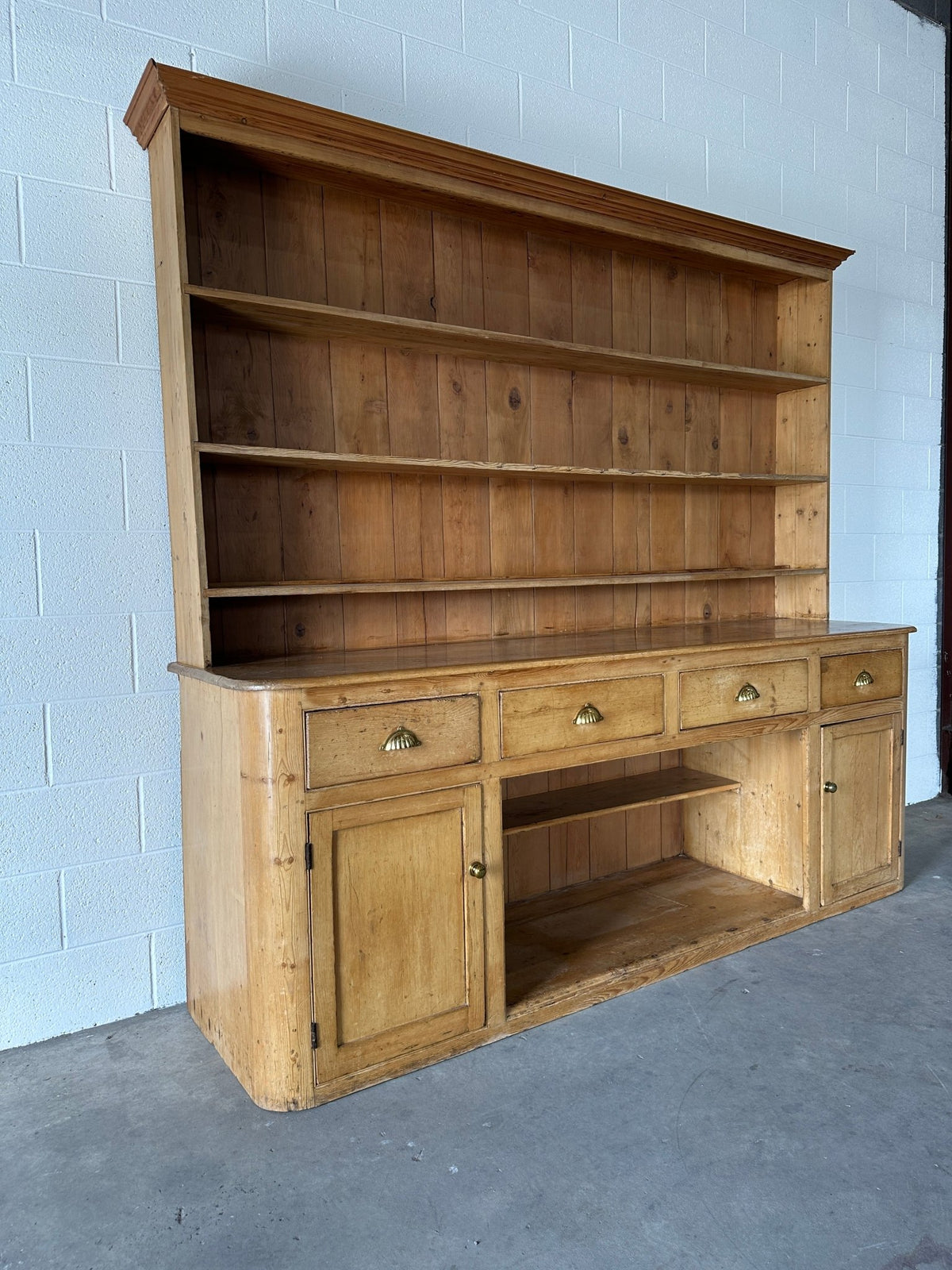 Monumental English pine kitchen dresser with brass pulls and a rounded base - House on Horizon