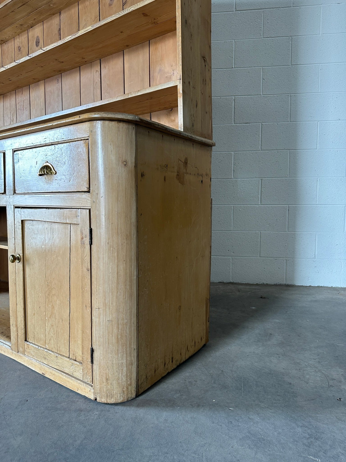 Monumental English pine kitchen dresser with brass pulls and a rounded base - House on Horizon