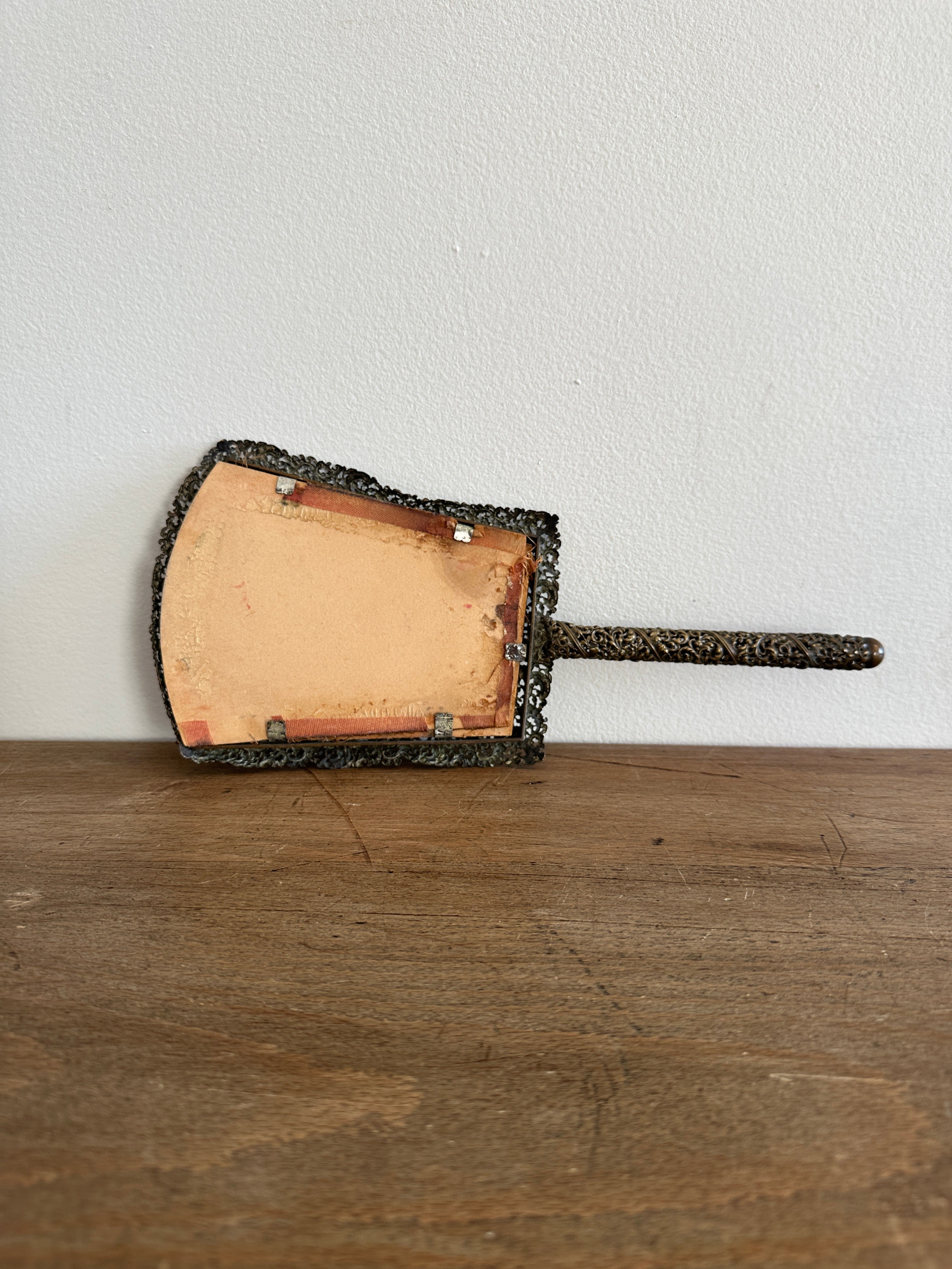Antique hand mirror in a metal frame