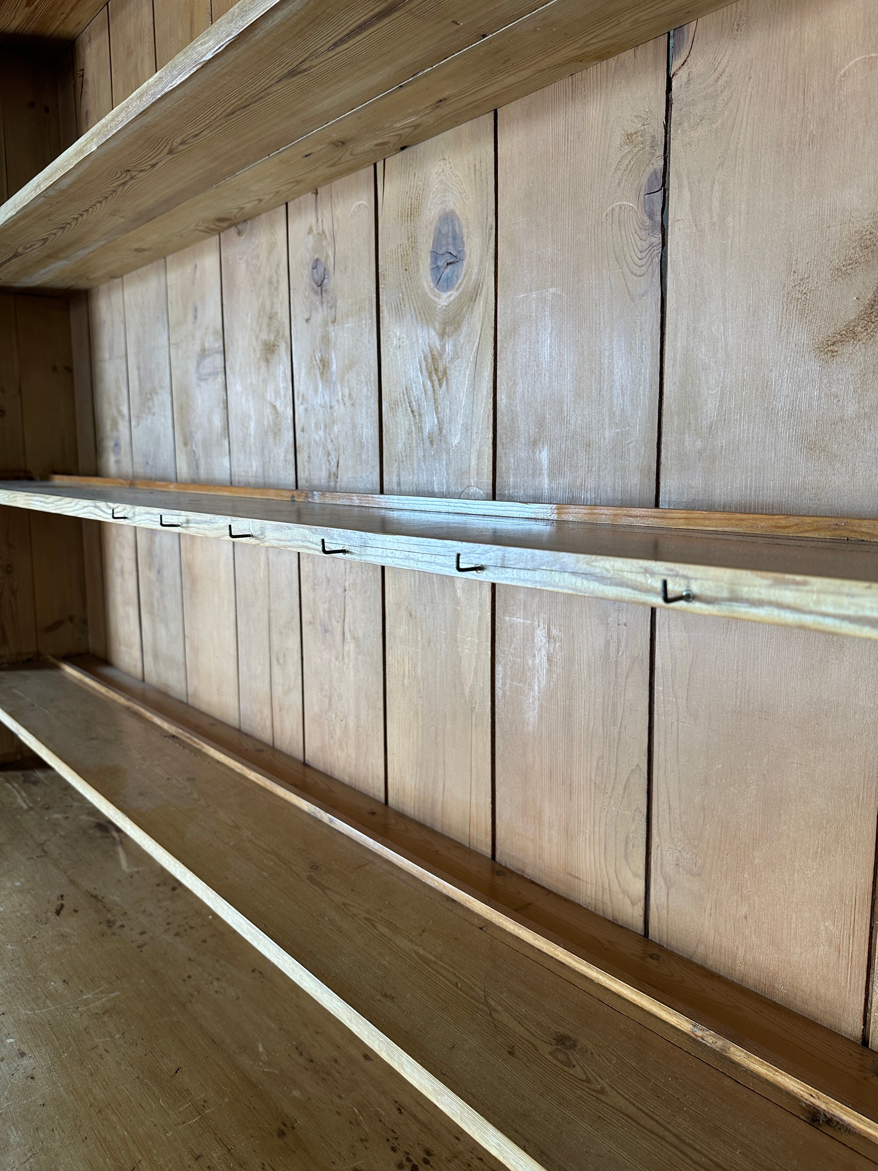 Monumental English pine kitchen dresser with brass pulls and a rounded base