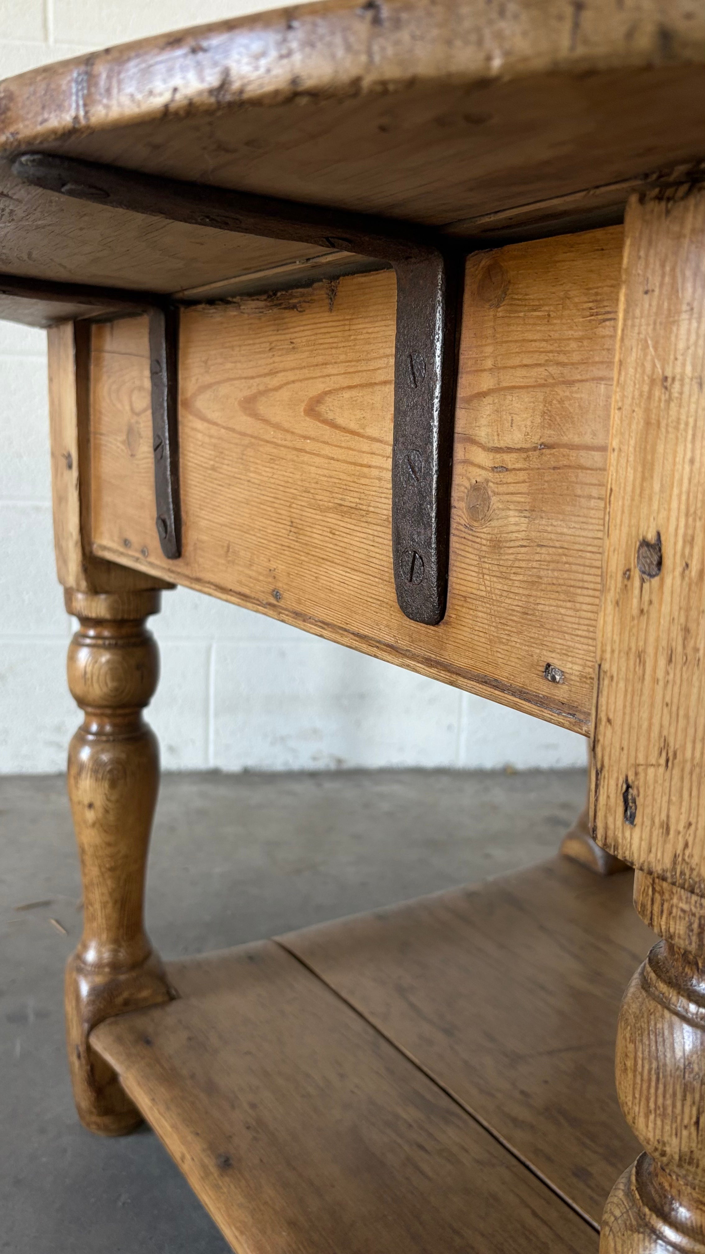 Small round pine coffee table with lower shelf