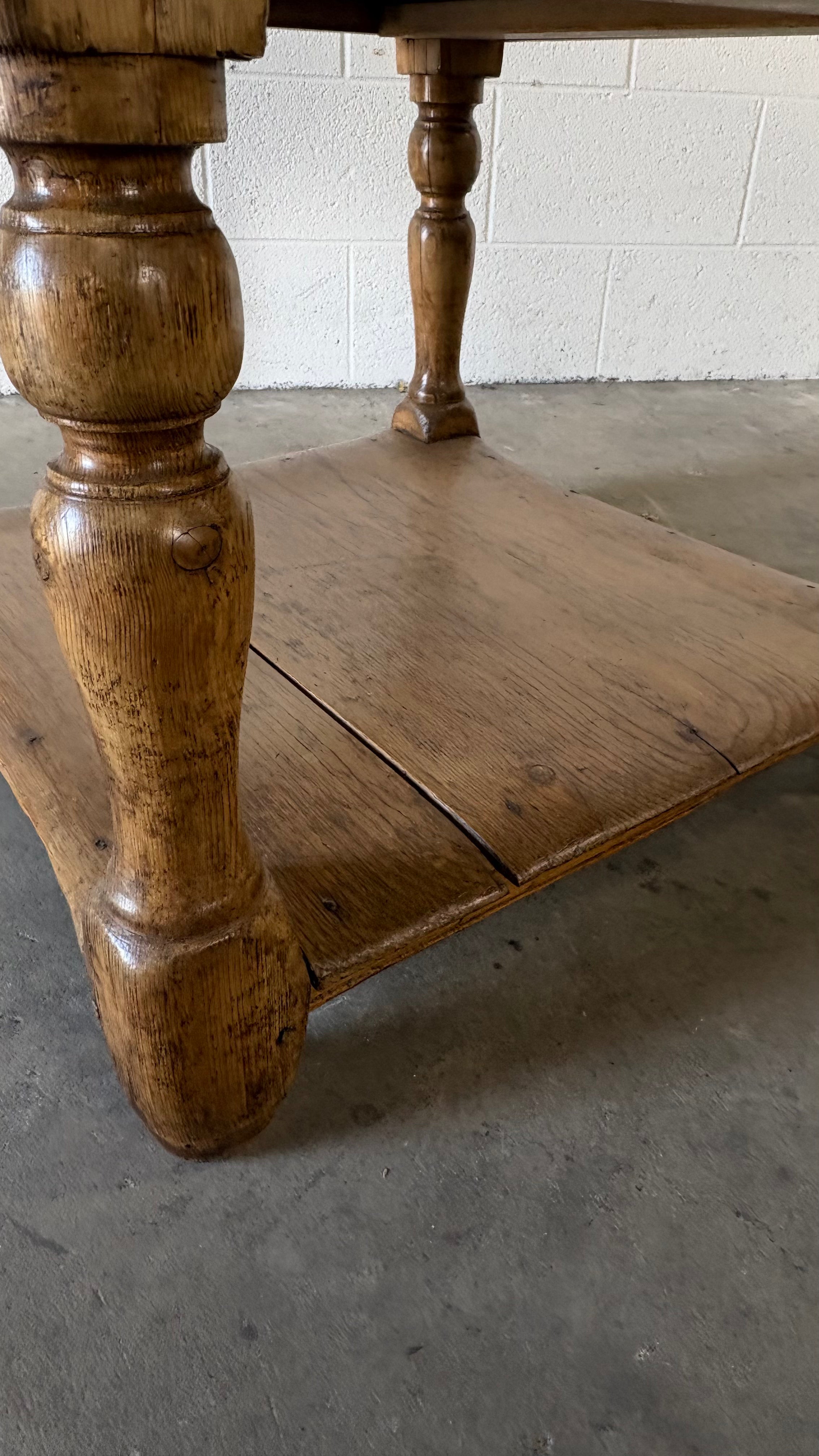 Small round pine coffee table with lower shelf