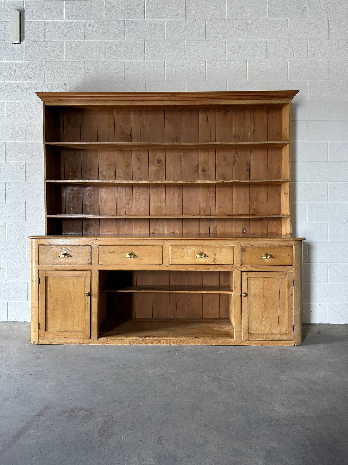 Monumental English pine kitchen dresser with brass pulls and a rounded base - House on Horizon