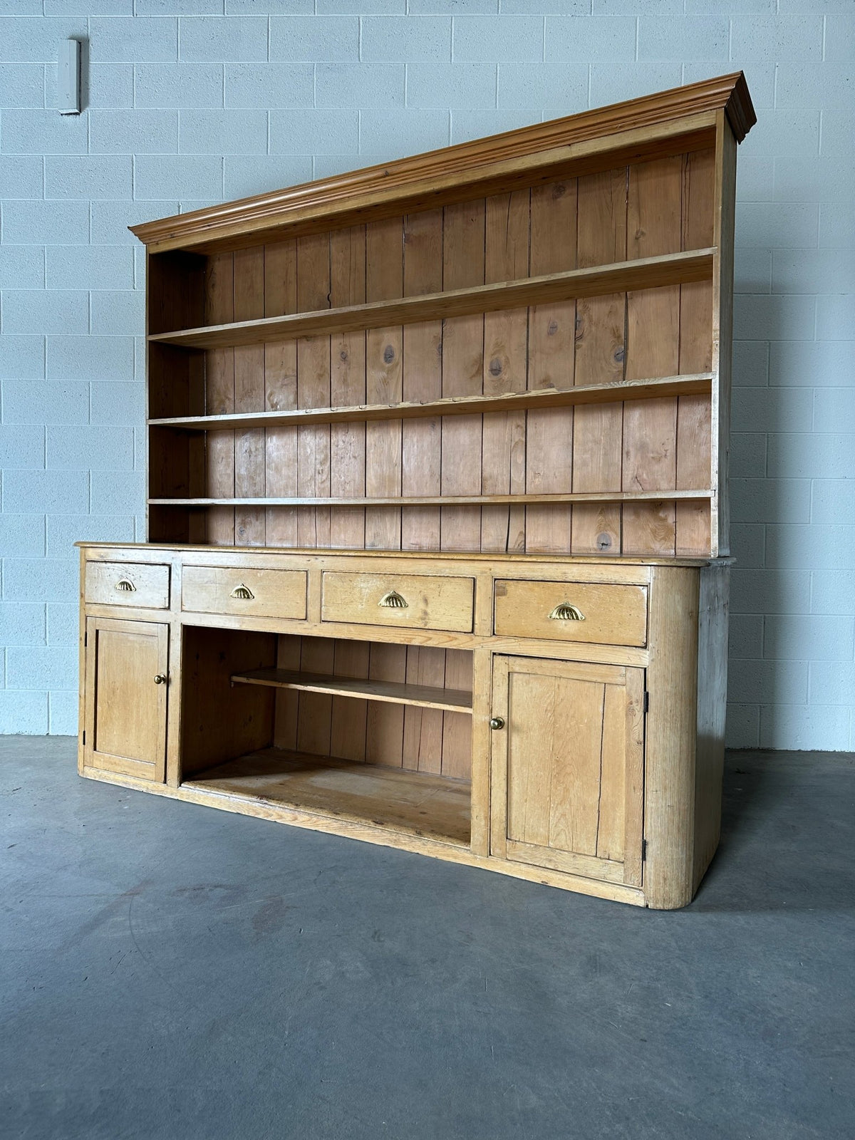 Monumental English pine kitchen dresser with brass pulls and a rounded base - House on Horizon